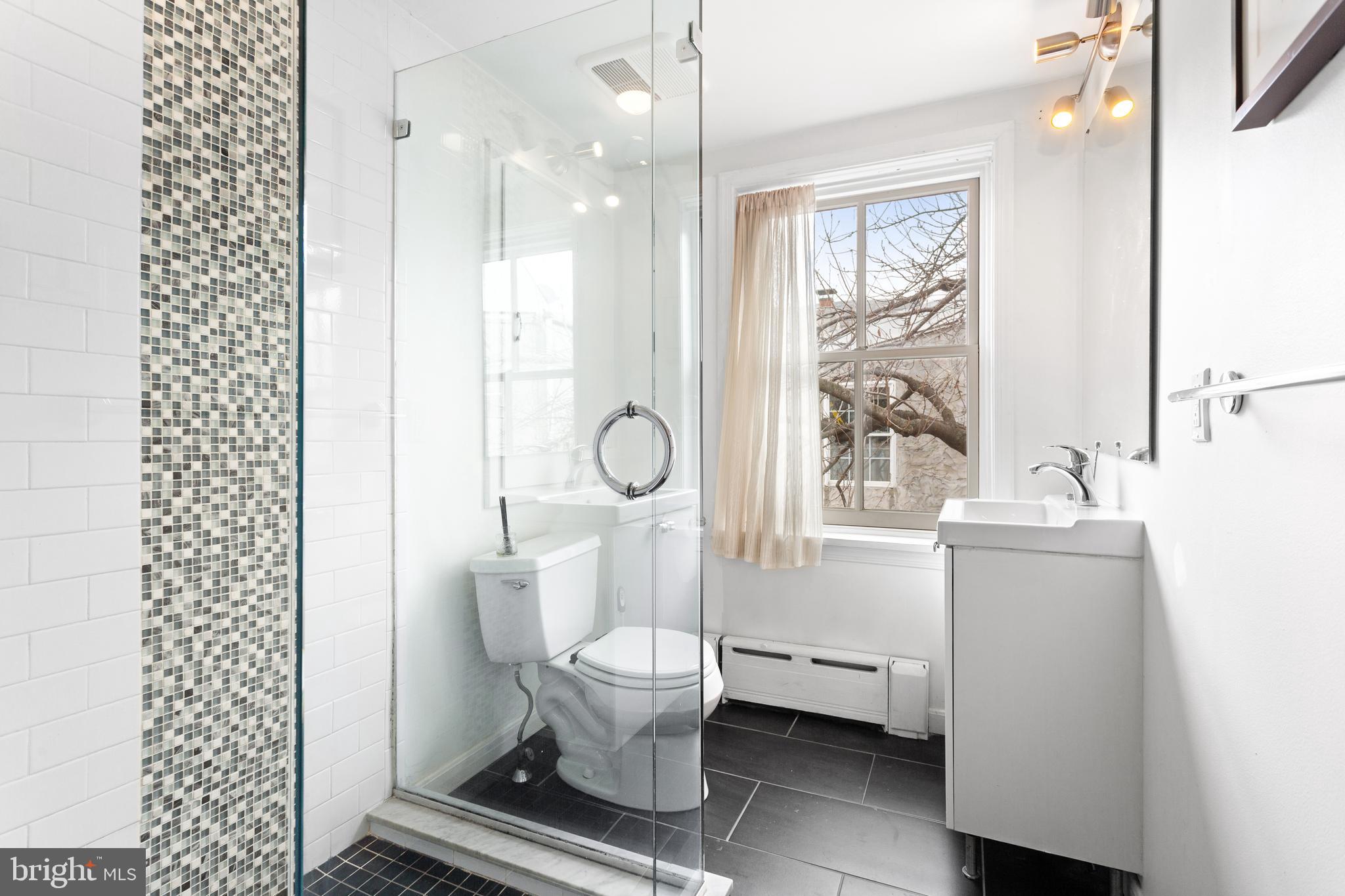 504 Kauffman Street Philadelphia, PA 19147 - Photo 22 of 34 a bathroom with a toilet sink a mirror and a shower