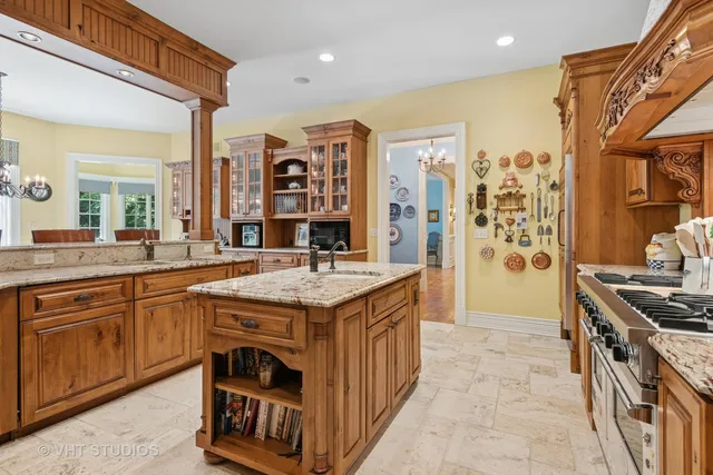 a large kitchen with stainless steel appliances a large counter top a stove and a refrigerator