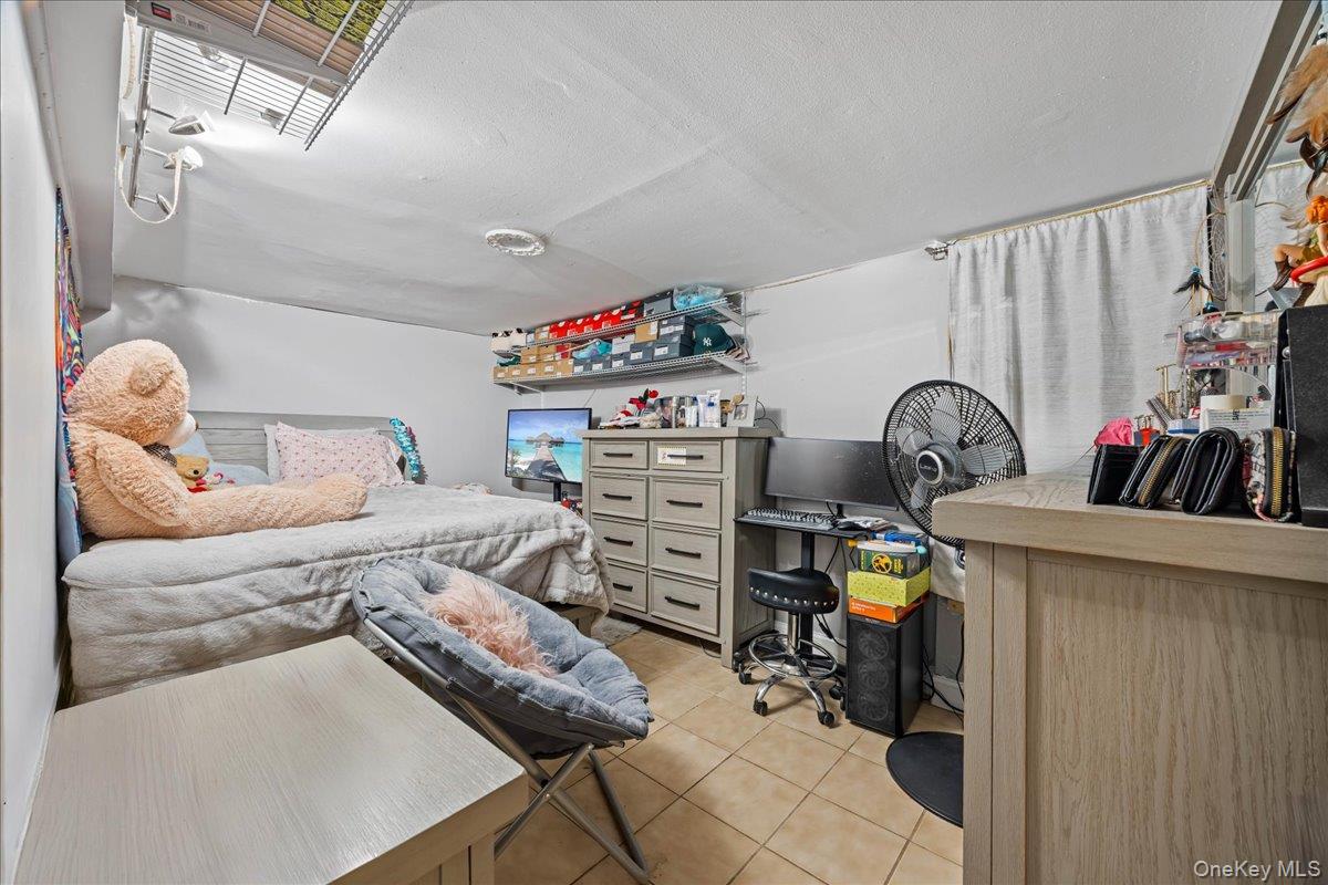 2953 Harding Avenue Bronx, NY 10465 - Photo 22 of 29 Bedroom with a desk, light tile patterned floors, and a textured ceiling