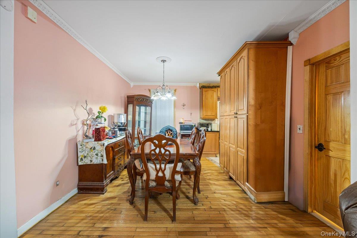 2953 Harding Avenue Bronx, NY 10465 - Photo 5 of 29 Dining space featuring a chandelier, ornamental molding, and light wood-type flooring