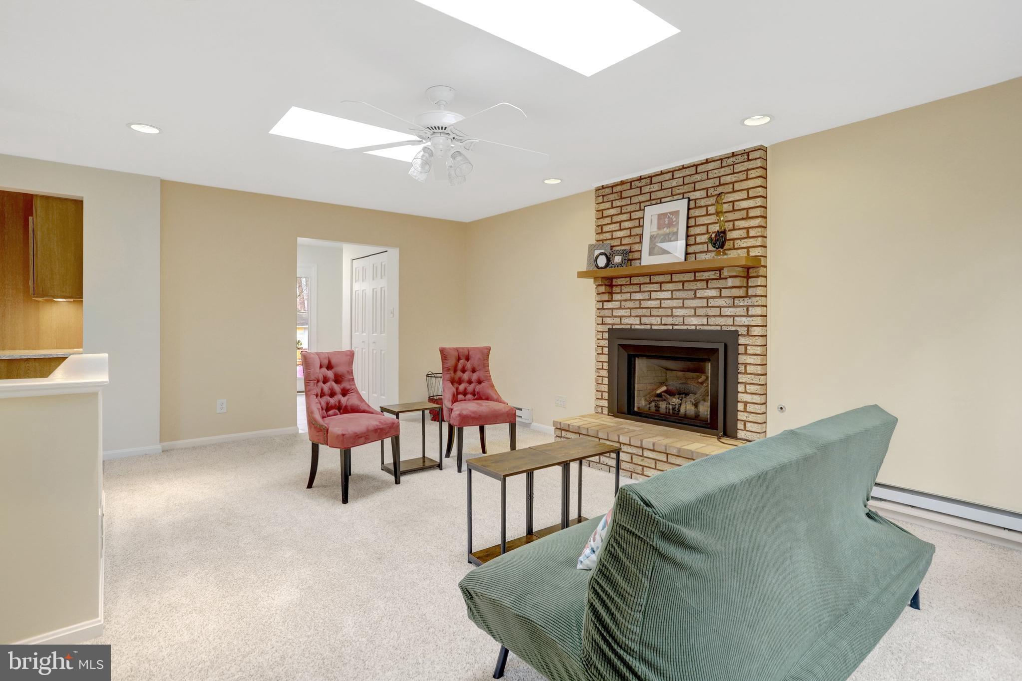8816 Victoria Road Springfield, VA 22151 - Photo 19 of 76 a living room with furniture a fireplace and a table