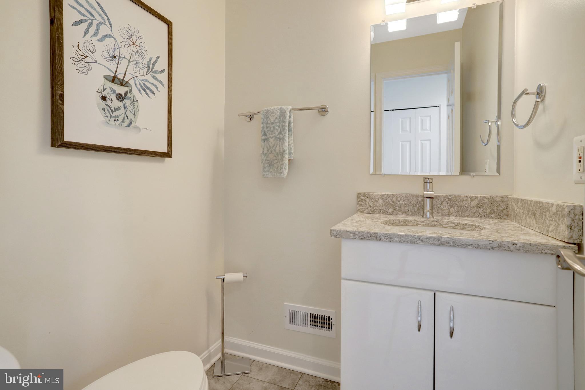 8816 Victoria Road Springfield, VA 22151 - Photo 60 of 76 a bathroom with a granite countertop sink mirror vanity and toilet