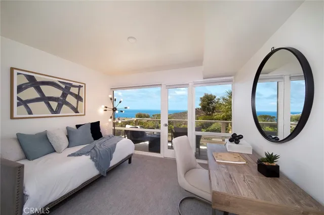 a living room with furniture and a mirror next to a window