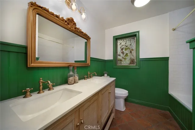 a bathroom with a sink a toilet and mirror