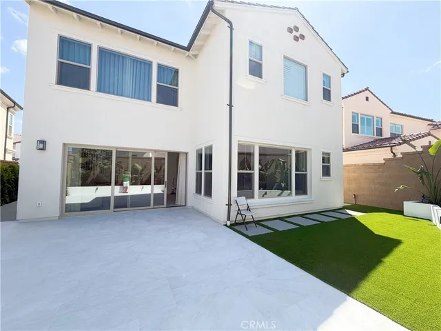 a view of a white house with a yard and a large window