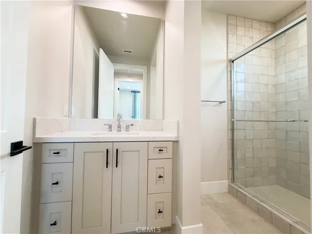 a bathroom with a shower sink and mirror