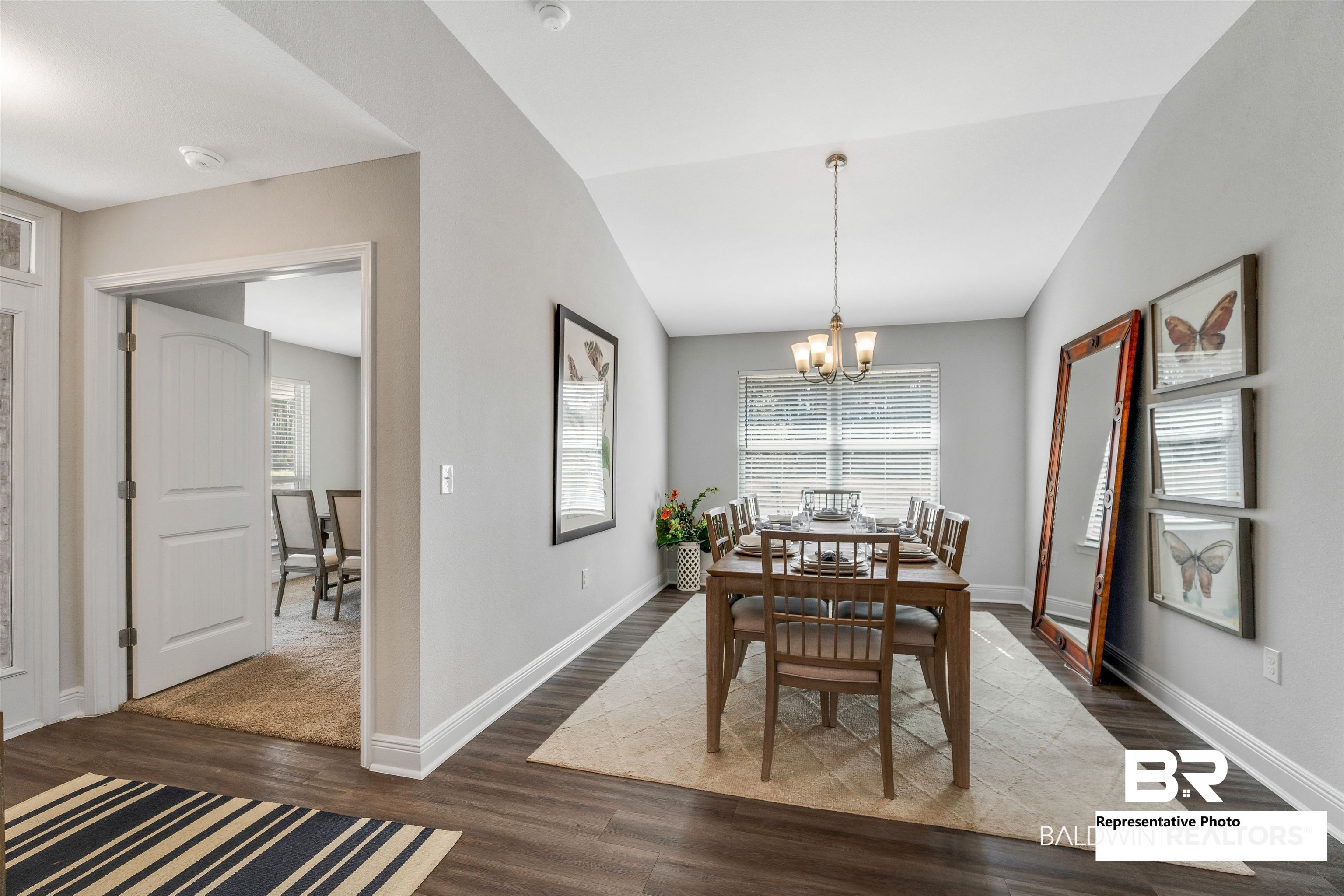 660 Mayflower Drive Foley, AL 36535 - Photo 19 of 36 Dining room with dark hardwood / wood-style flooring, a wealth of natural light, a chandelier, and vaulted ceiling