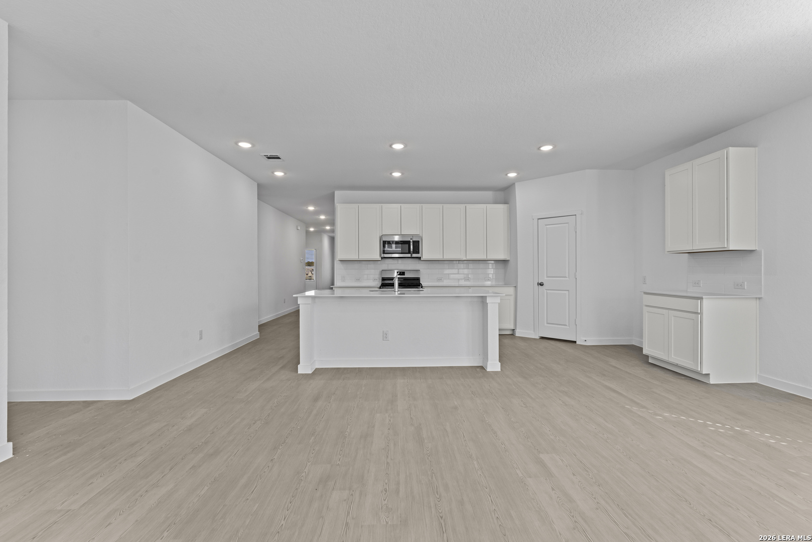2315 Fort Davis Pass Marion, TX 78124 - Photo 4 of 31 a large white kitchen with kitchen island a sink a refrigerator and white cabinets