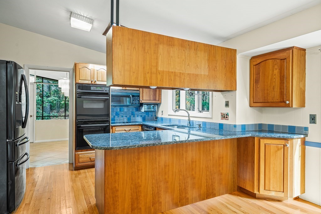 15 Partridge Road Lexington, MA 02420 - Photo 4 of 22 a view of a kitchen with kitchen island a large window cabinets and stainless steel appliances