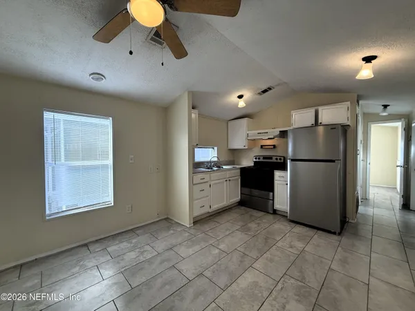 a kitchen with stainless steel appliances granite countertop a refrigerator a stove a sink and a refrigerator