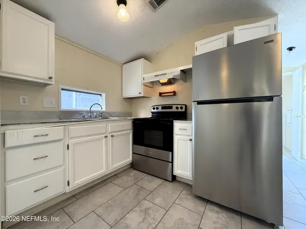 a kitchen with stainless steel appliances white cabinets and a refrigerator