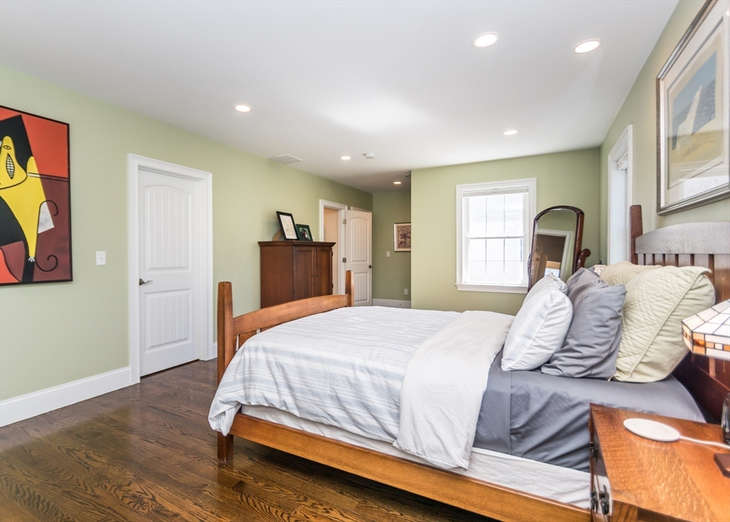 128 Church Street, Unit 2 Waltham, MA 02452 - Photo 28 of 41 a bedroom with a bed and a large mirror on the dresser
