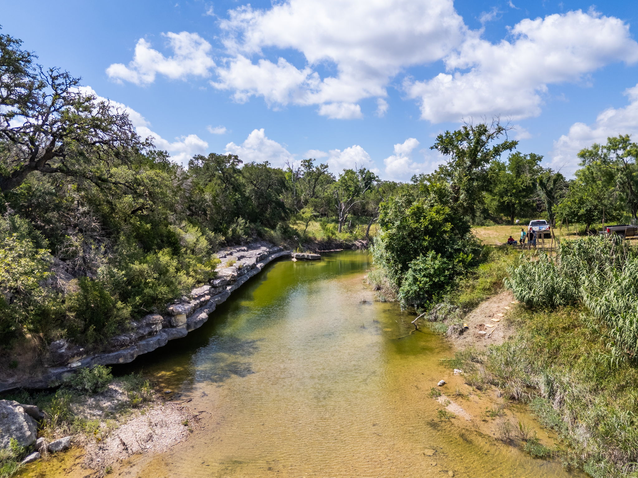 5385 Ranch Road 165 Blanco, TX 78606 - Photo 39 of 40 A tranquil watercourse meanders through verdant banks, inviting serene riverside moments.