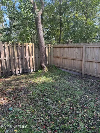 a view of a backyard with a fence and a fence