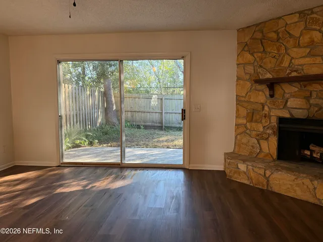a view of empty room with wooden floor and fireplace