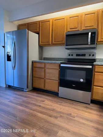 a kitchen with granite countertop a stove and a microwave
