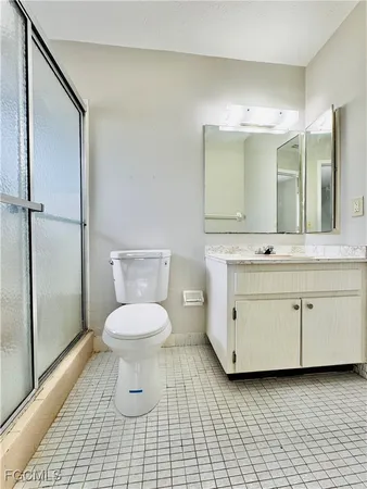 a bathroom with a granite countertop toilet a sink a mirror and vanity