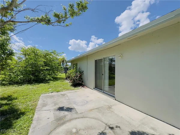 a view of a house with a yard and potted plants