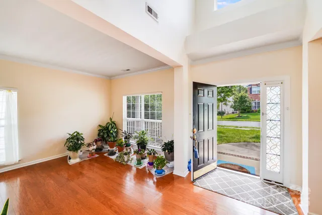 an empty room with floor to ceiling windows and wooden floor