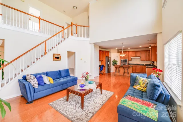 a living room with furniture and a dining table with wooden floor