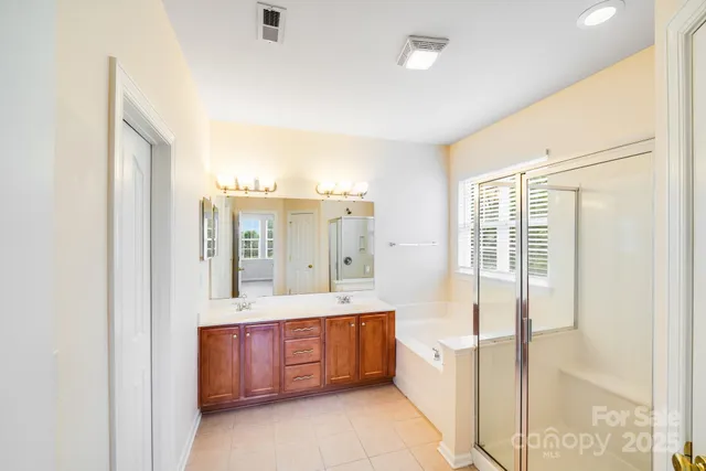 a spacious bathroom with a tub sink and mirror