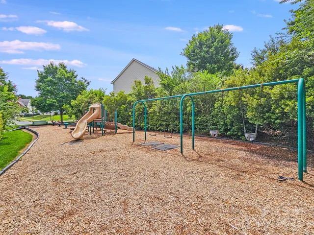 an aerial view of a house with a yard and a large tree