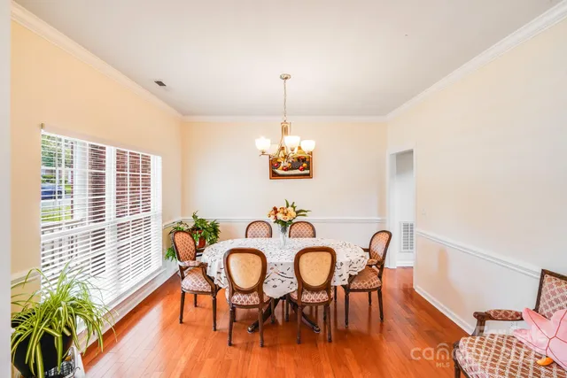 a dining room with furniture a window and wooden floor