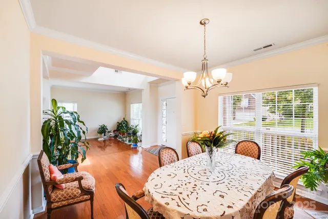 a view of a dining room with furniture and chandelier
