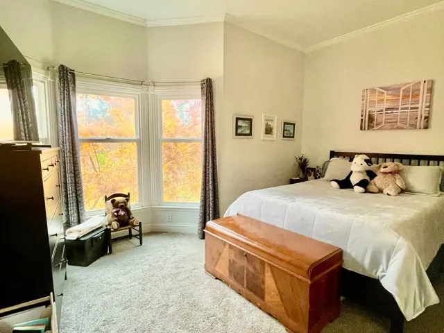 a bedroom with a bed and a large window