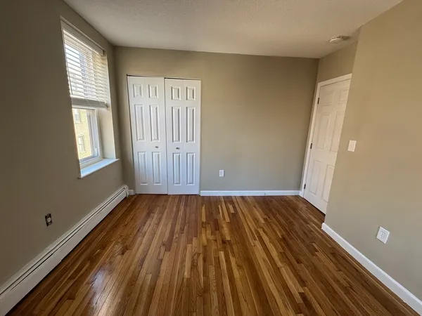 a view of a room with wooden floor and window