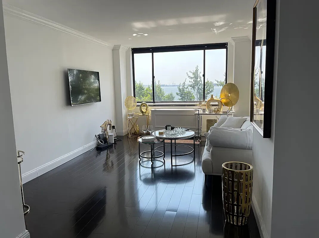 377 Rector Place, Unit 4L Manhattan, NY 10280 - Photo 2 of 10 a living room with furniture and a flat screen tv