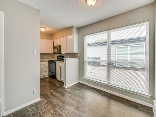 a kitchen with a refrigerator a stove top oven and a large window