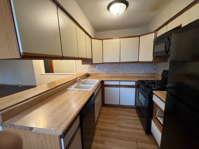 a kitchen with stainless steel appliances granite countertop a sink counter space cabinets and a stove