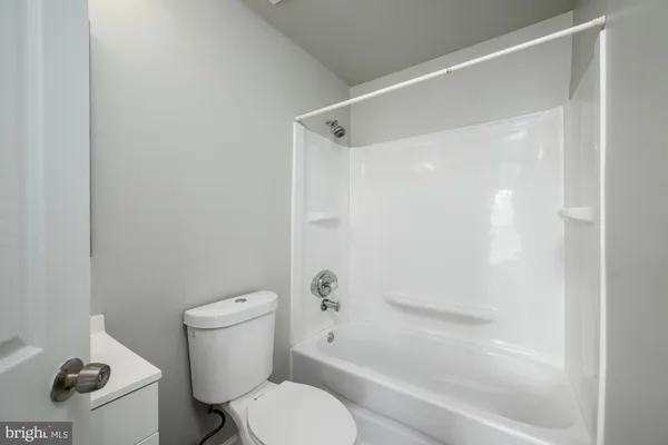 a white toilet sitting next to a bath tub