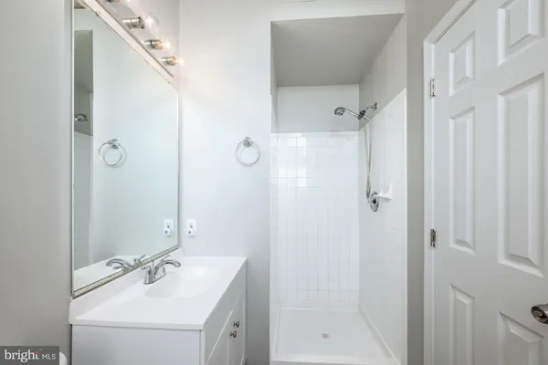 a bathroom with a shower sink vanity and mirror