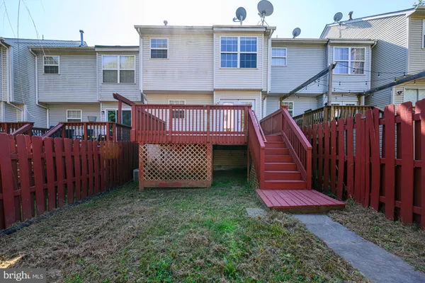 a view of a backyard with plants and wooden fence