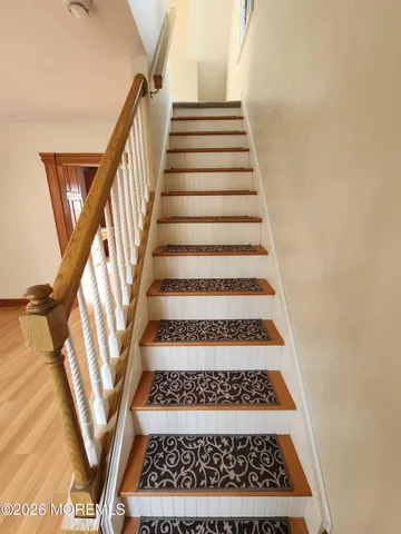 a view of staircase with white walls and a rug