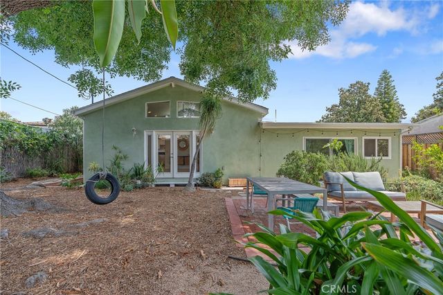 a view of a chairs and table in the backyard