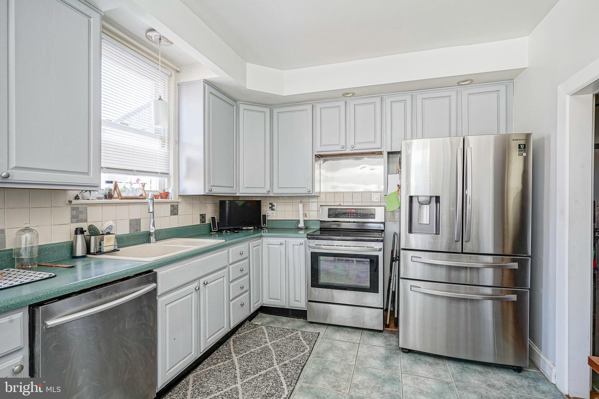 1919 Lansing Street Philadelphia, PA 19111 - Photo 7 of 22 a kitchen with a refrigerator sink and cabinets