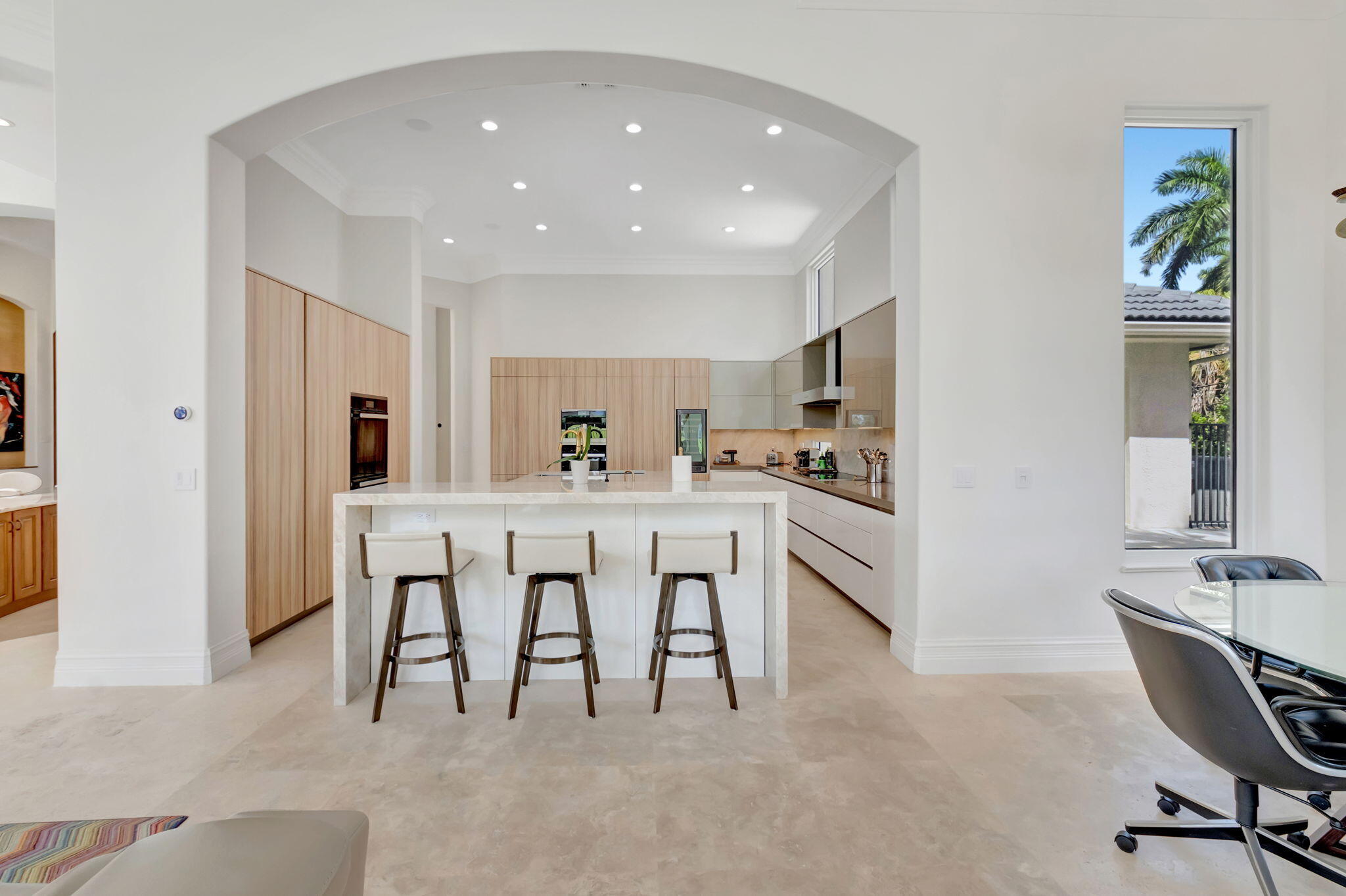7090 Ayrshire Lane Boca Raton, FL 33496 - Photo 15 of 48 a kitchen with kitchen island a dining table chairs cabinets and stainless steel appliances