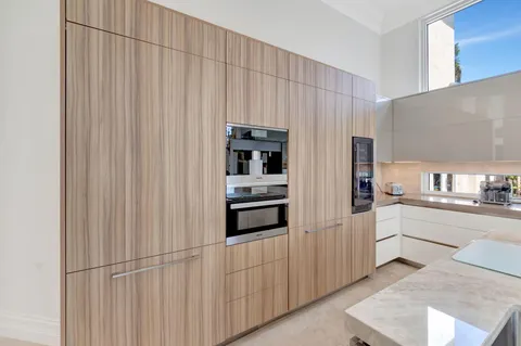 a large white kitchen with sink and wooden floor