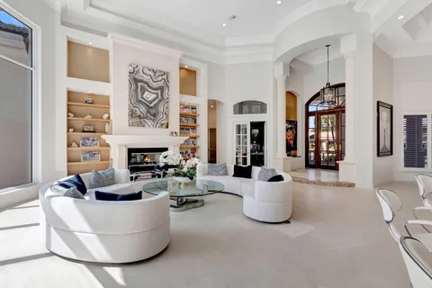 a living room with furniture a fireplace and a chandelier