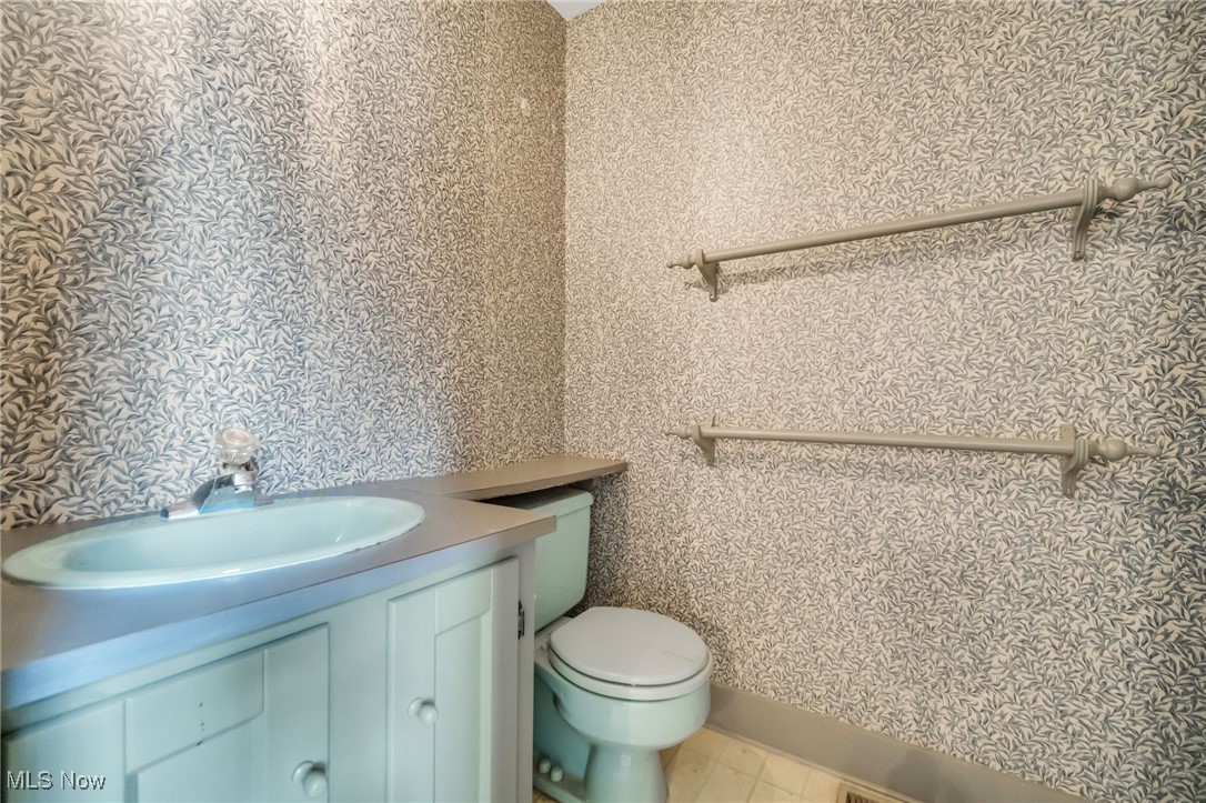 18060 Falling Leaves Road Strongsville, OH 44136 - Photo 30 of 43 Half bath with toilet, wallpapered walls, and vanity