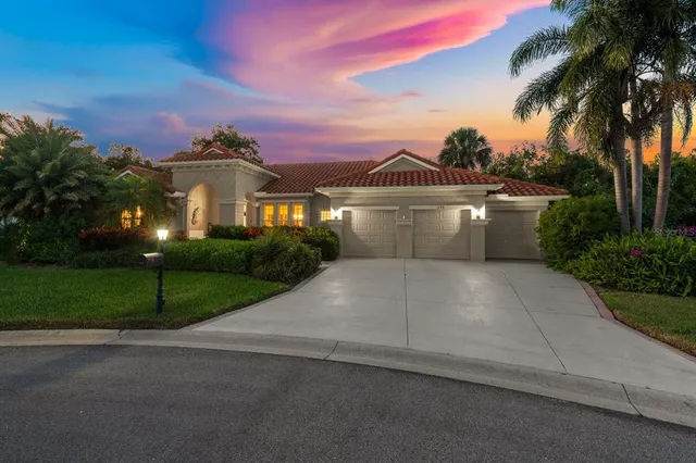 a view of a house with a yard and palm trees