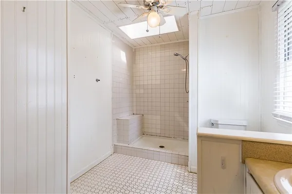 an empty room with a ceiling fan and a window