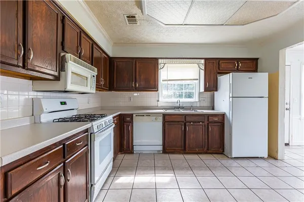 a kitchen with a refrigerator a stove a sink and cabinets