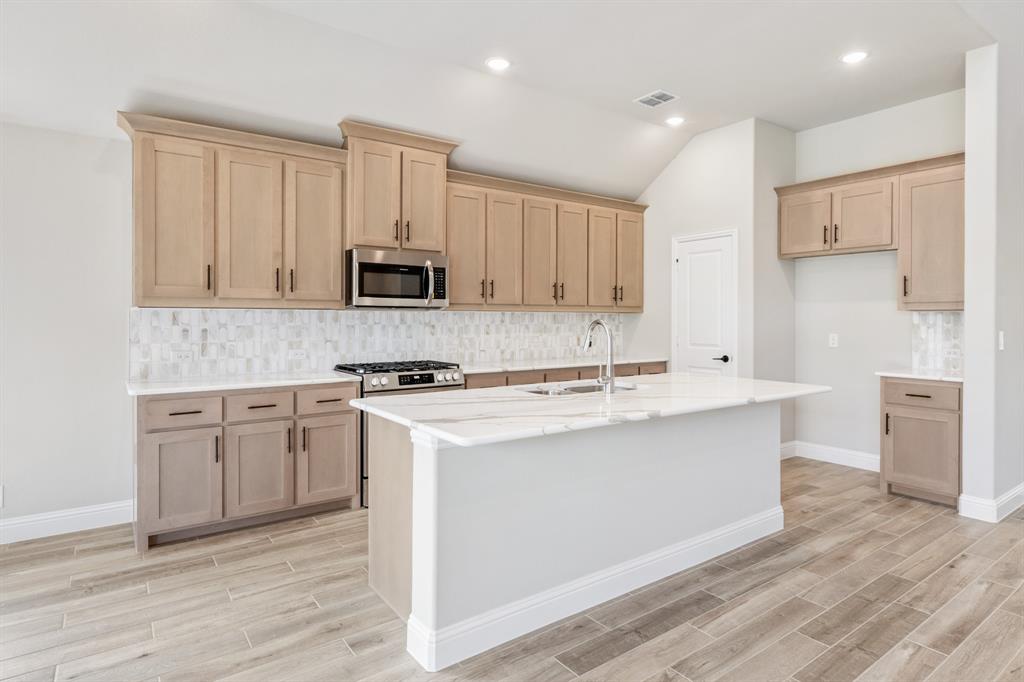 2016 Dundalk Lane Forney, TX 75126 - Photo 13 of 40 a kitchen with stainless steel appliances a stove top oven a sink and white cabinets