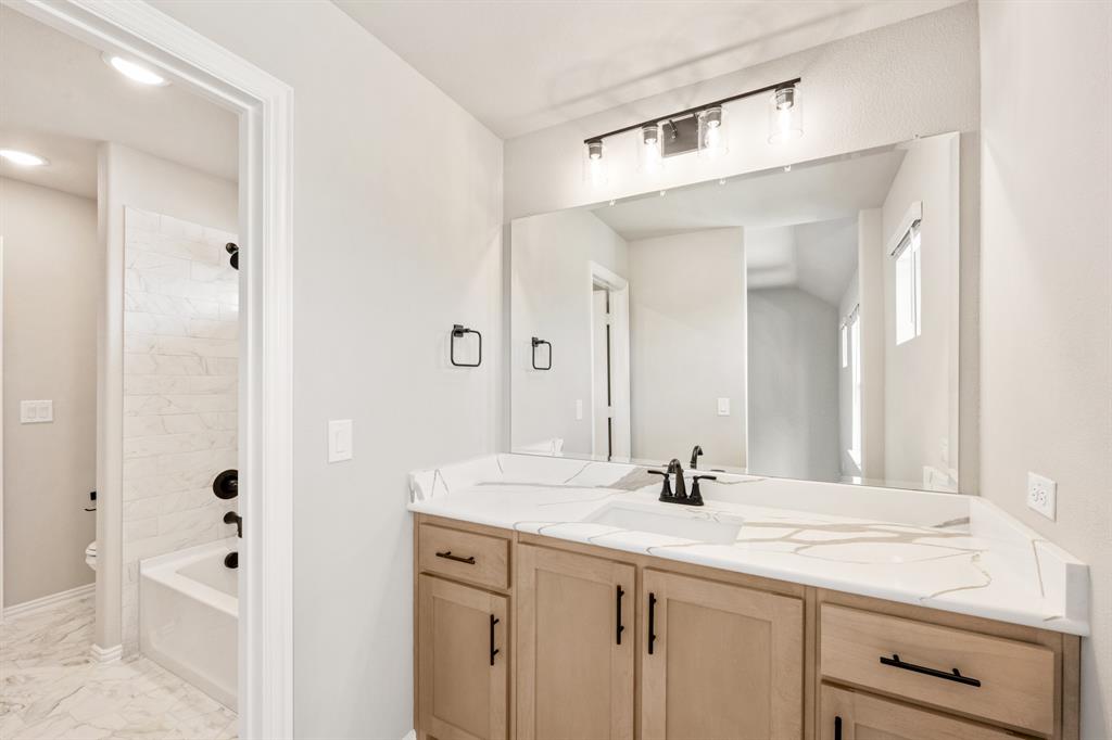 2016 Dundalk Lane Forney, TX 75126 - Photo 33 of 40 a bathroom with a granite countertop sink a mirror and a bathtub