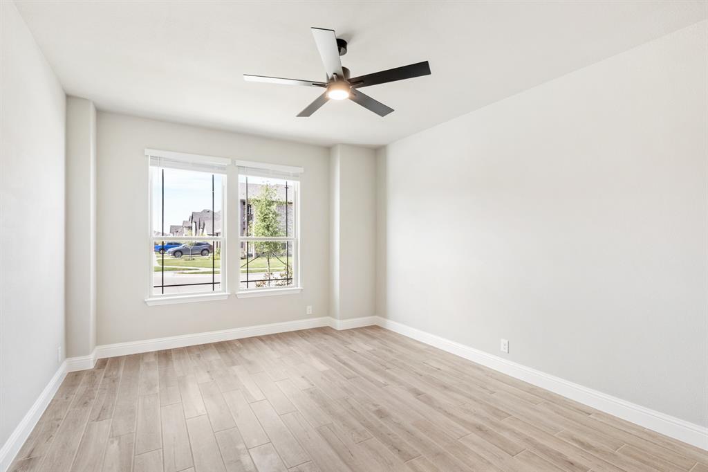2016 Dundalk Lane Forney, TX 75126 - Photo 6 of 40 an empty room with wooden floor fan and windows