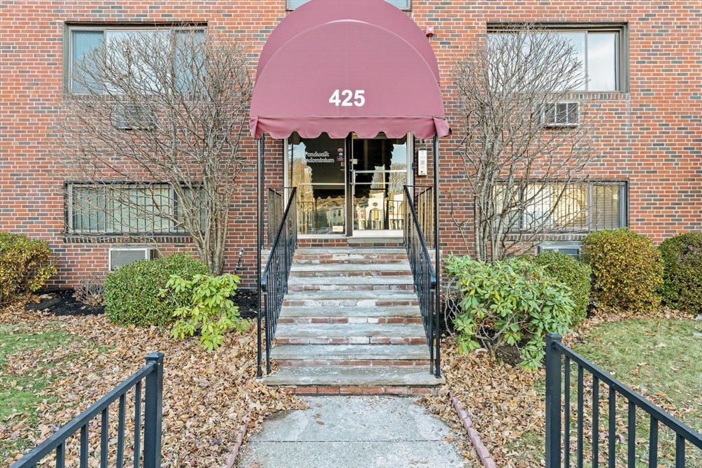 a front view of a house with plants